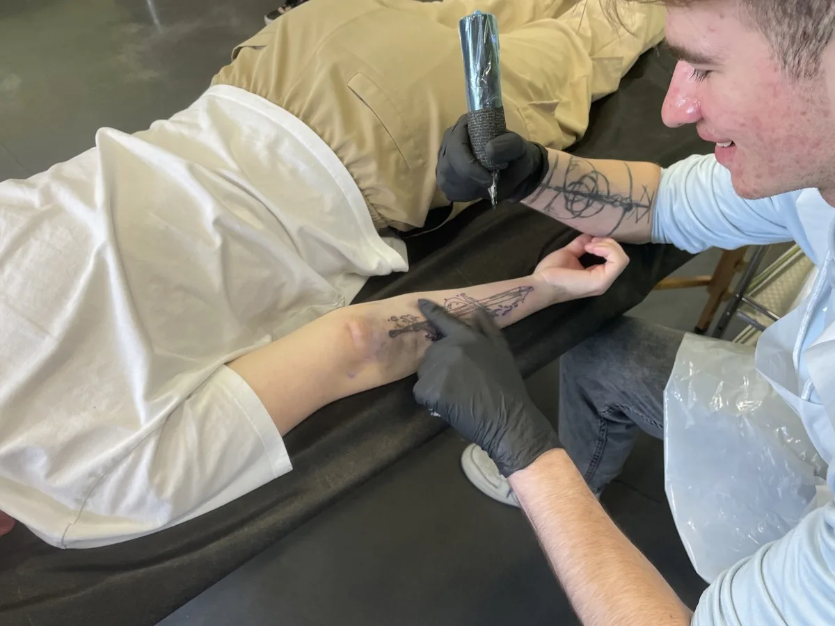 Fine line sword tattoo on forearm