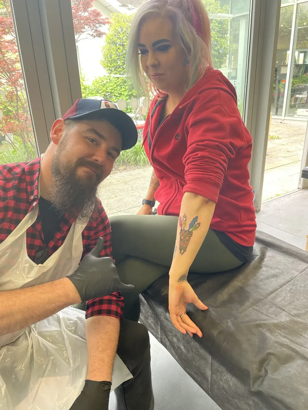 Tutor and client with a finished tattoo
