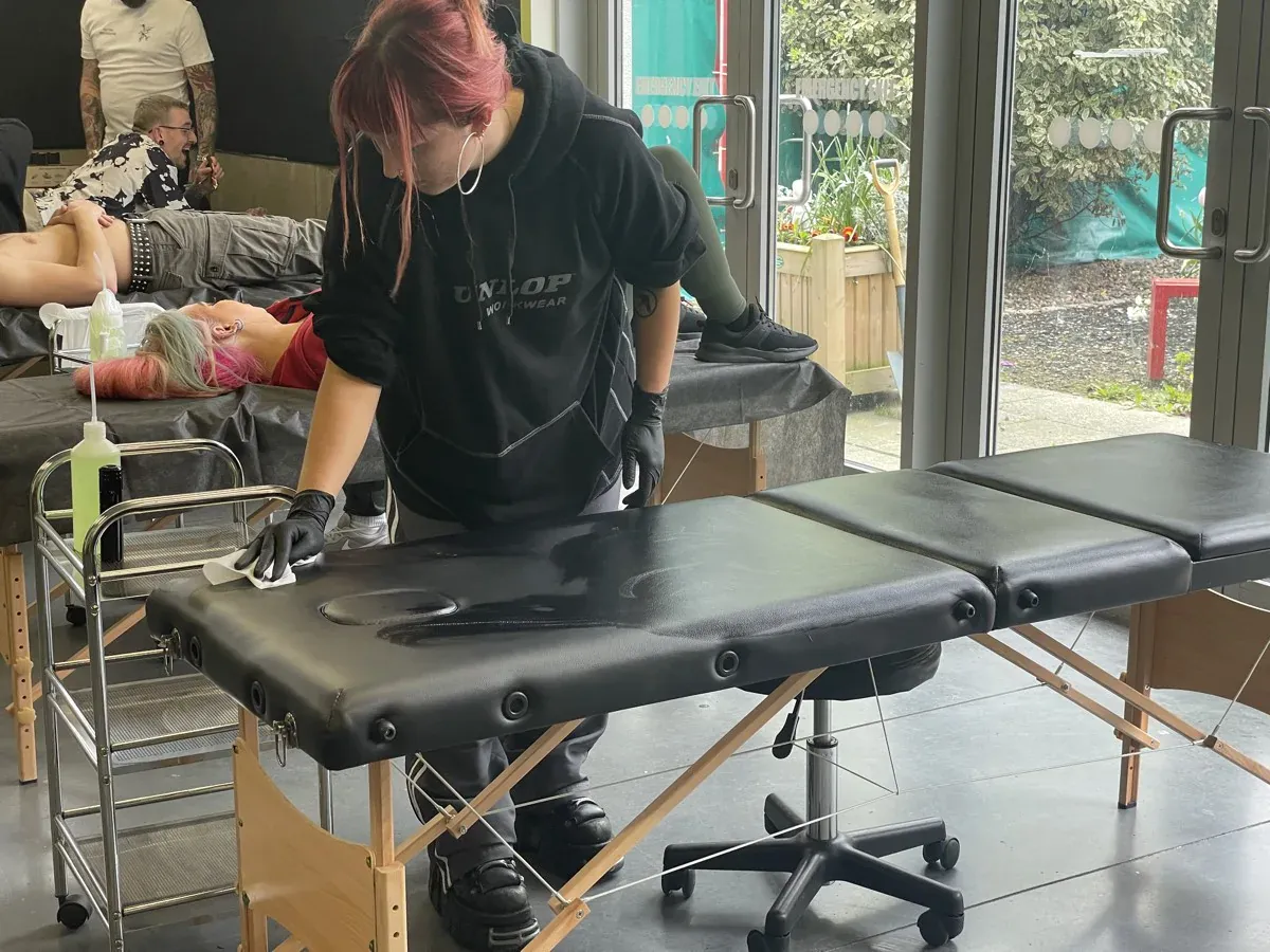 Cleaning a tattoo table between sessions