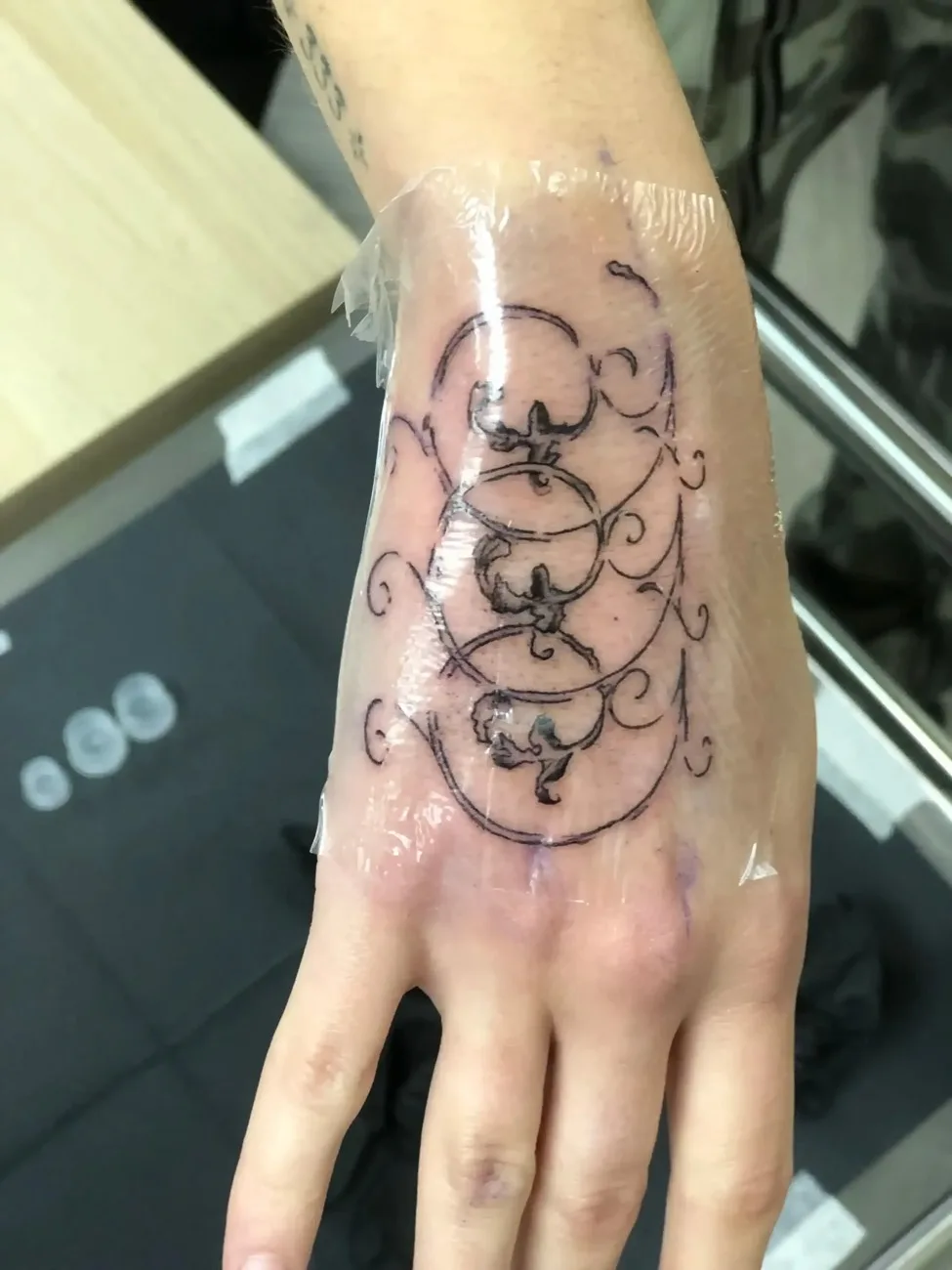 Fine line ornamental hand tattoo