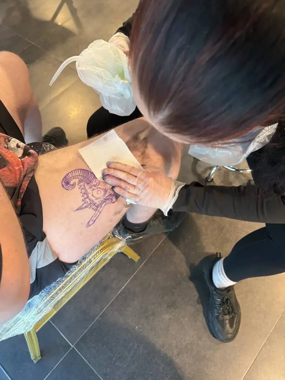 A tutor guiding a student in the Glasgow Tattoo College studio